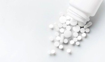 white pills spilling out of a white bottle onto a white background