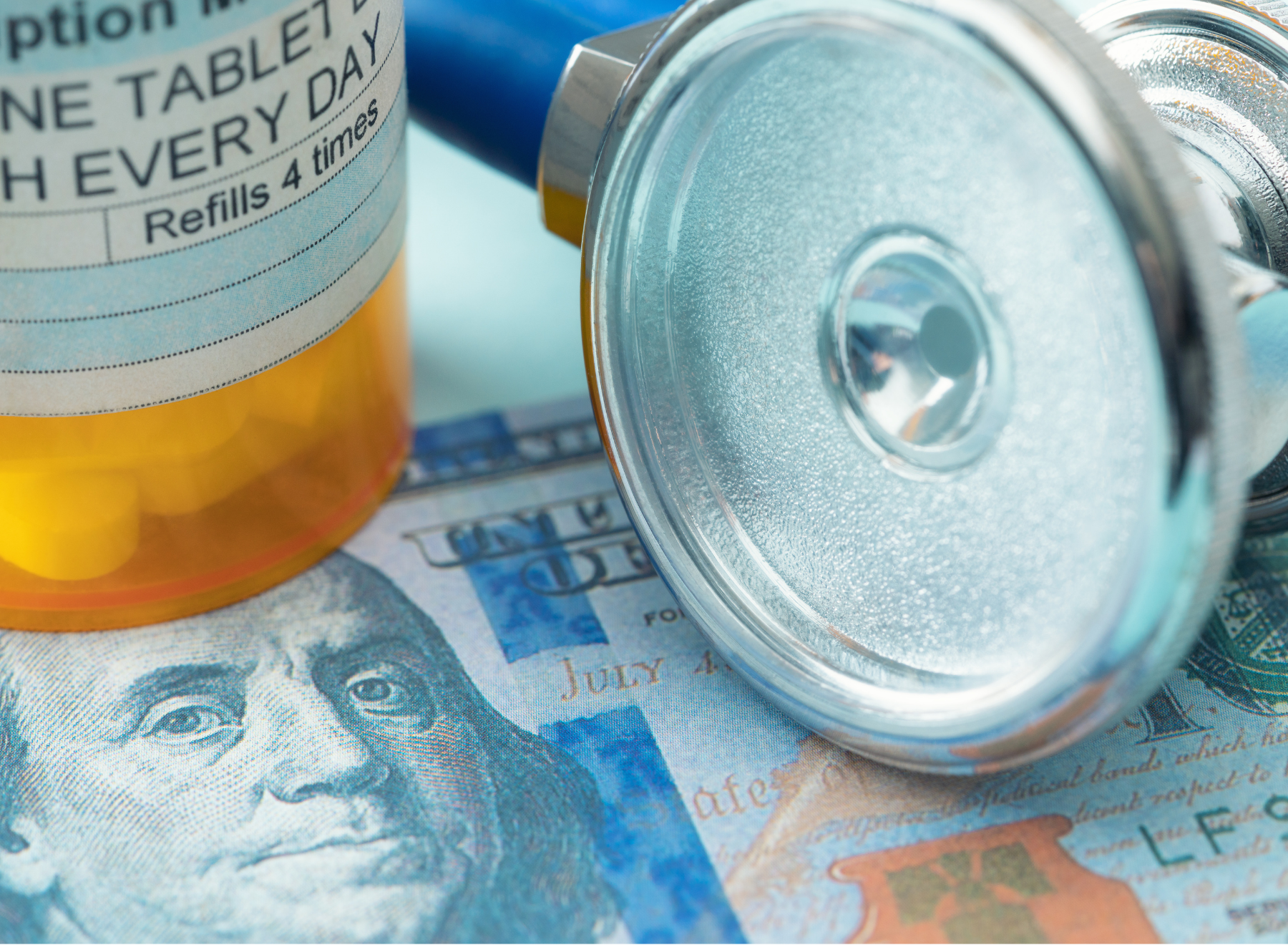 prescription bottle, one hundred dollar bill, and stethoscope
