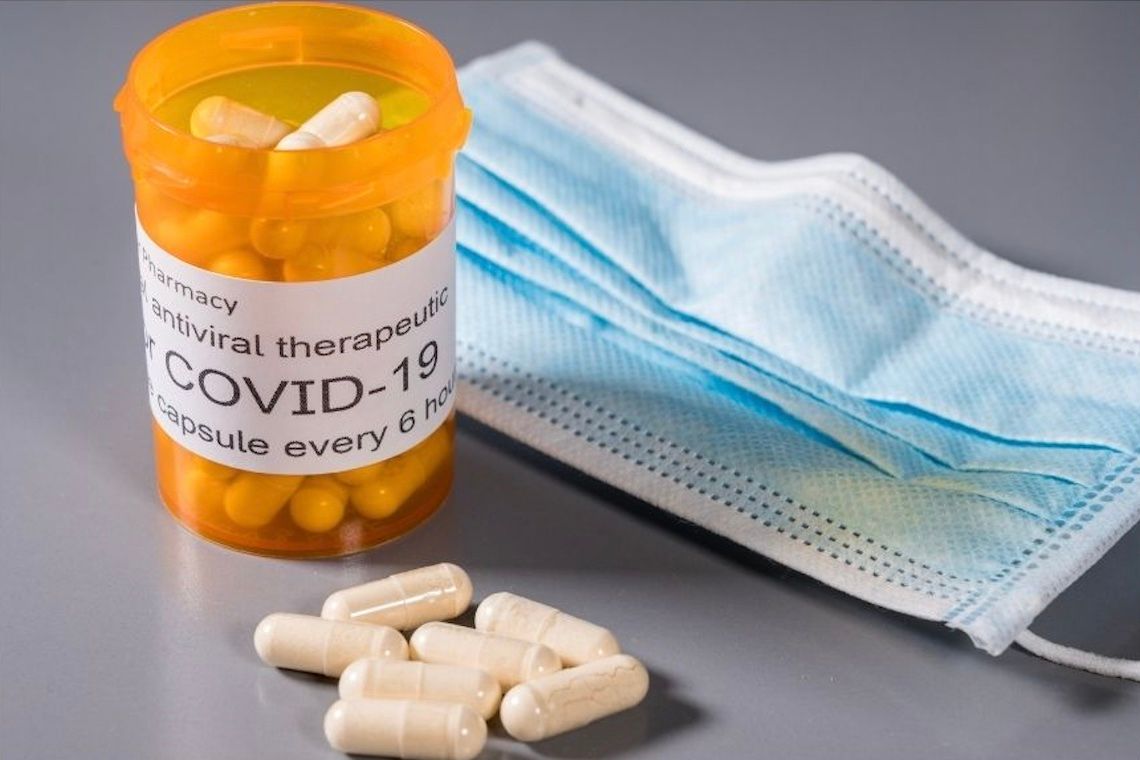 oral antiviral medication bottle and facemask
