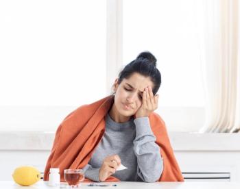 woman with the flu putting hand on her head