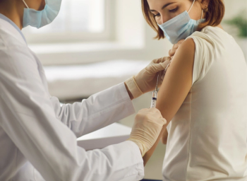 pharmacist administers COVID-19 shot