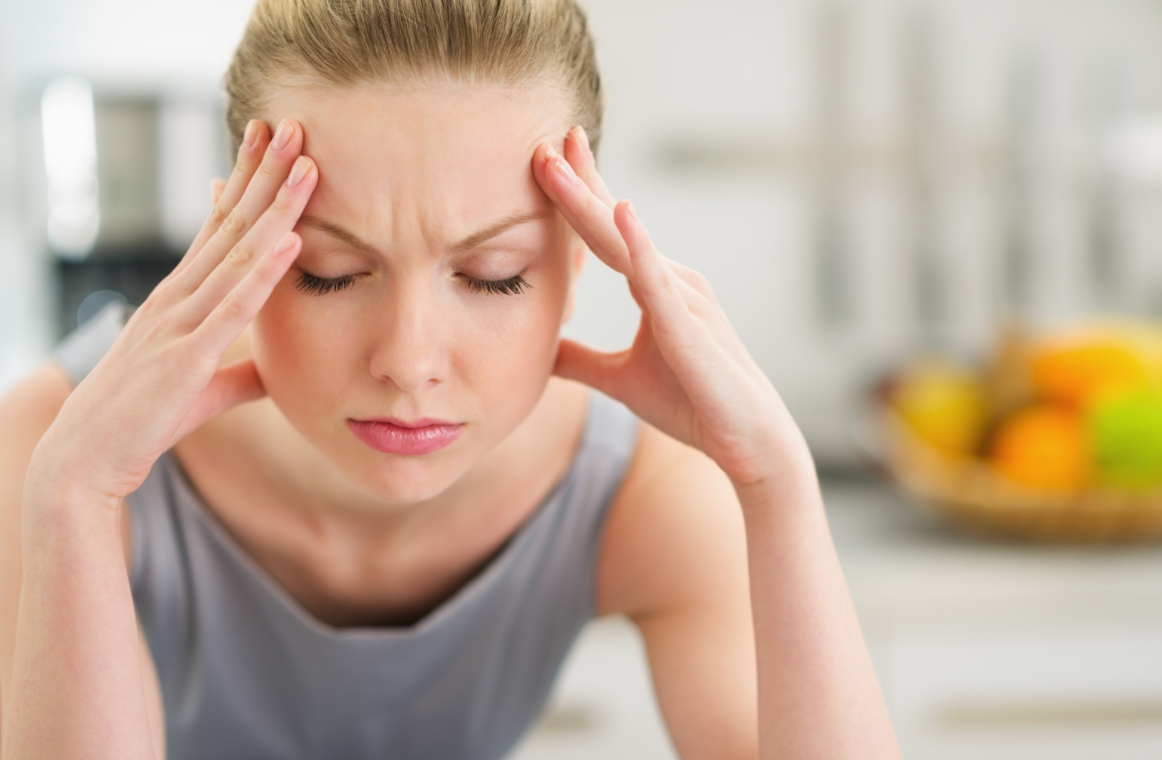 woman with hands on head in pain