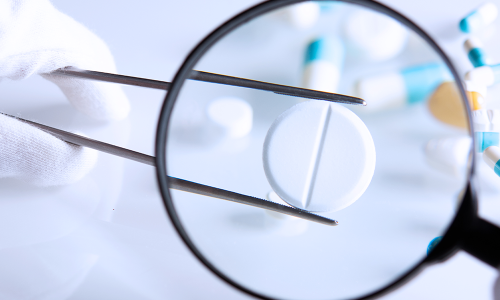 magnifying glass and pill