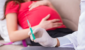 pregnant woman preparing to receive vaccination