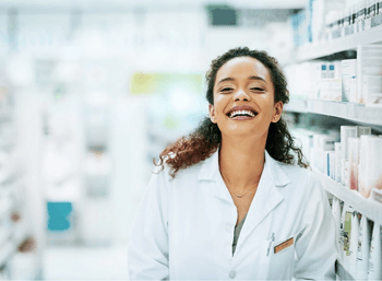 Pharmacist smiles in pharmacy aisle