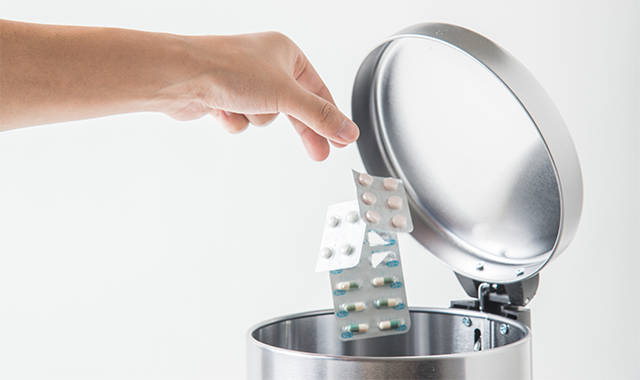 throwing pills in trash can
