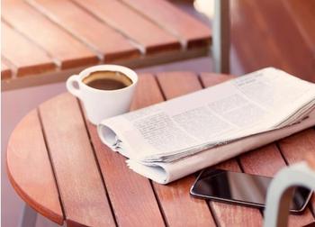 newspaper and phone on table
