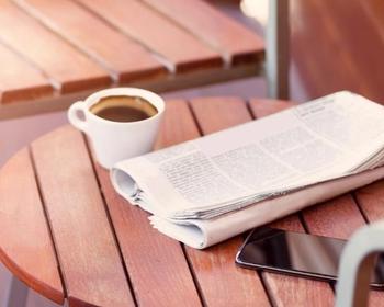 newspaper and phone on table
