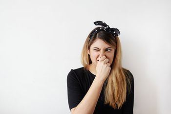 veterinary-woman-smells-bad-stink-holds-nose-AdobeStock_143979966-450.jpg