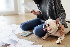 veterinary-woman-with-dog-looking-at-bills_AdobeStock_200321086-450-1.jpg