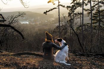 veterinary-girl-sitting-with-dog-in-forest-with-beautiful-view-450px-shutterstock-363896369.jpg