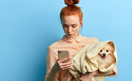 veterinary-dog-girl-holding-phone-pet-owner-AdobeStock_283463453-450.jpg