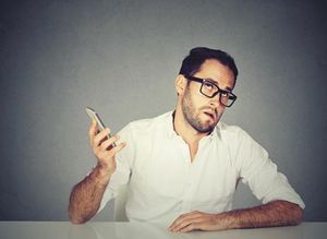 veterinary-closeup-annoyed-young-man-with-cellphone-450px-shutterstock-501638368.jpg
