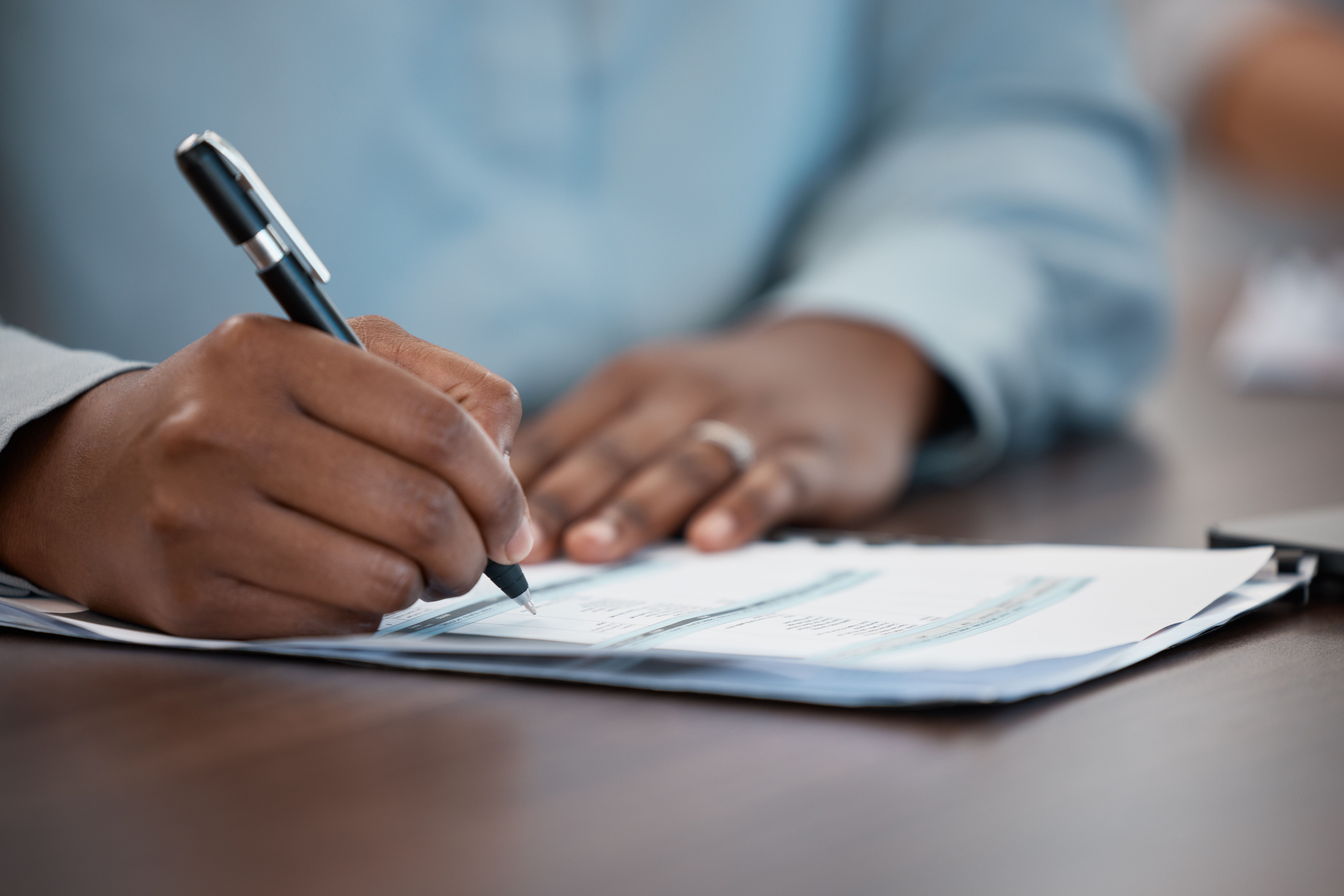 hand of a man signing documents
