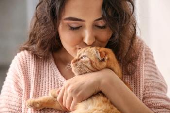 woman kissing cat