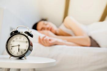 Woman sleeping with alarm clock