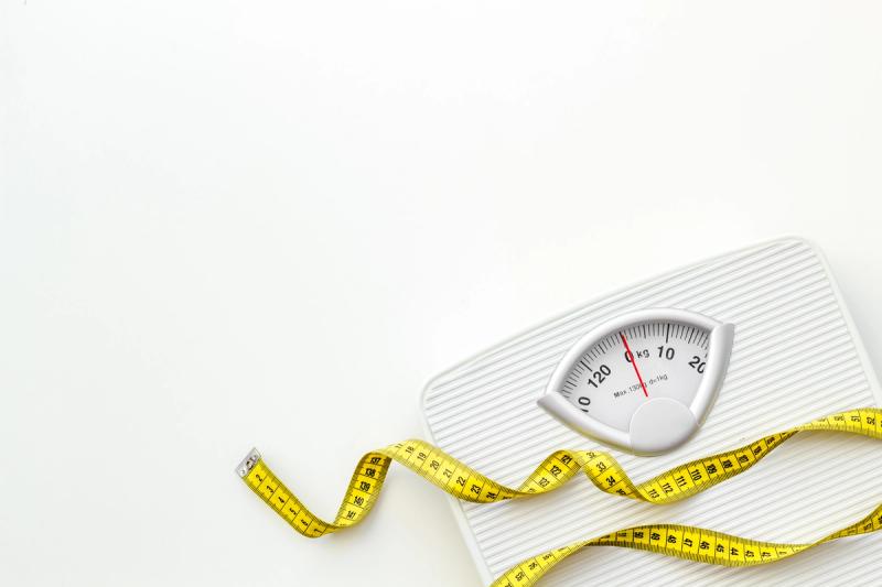 bathroom scales and measuring tape for weight loss concept on white background | Credit: Adobe Stock 