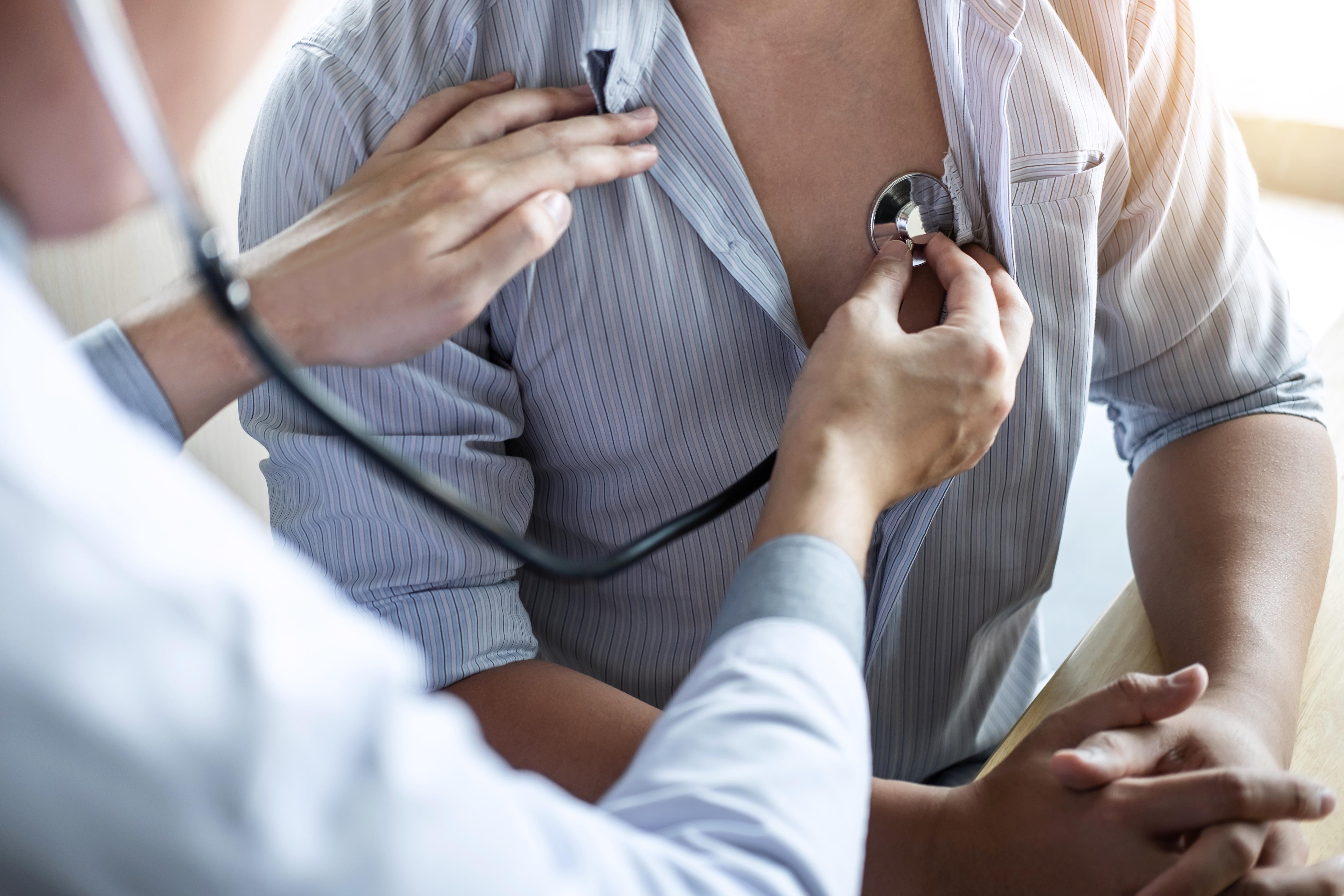 Doctor checking a patient's heart beat.