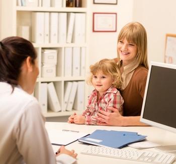 Mother and child sitting with doctor | Credit: Fotolia