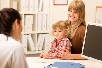 Mother and child sitting with doctor | Credit: Fotolia