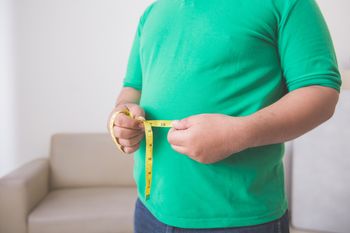Person measuring their waist circumference.