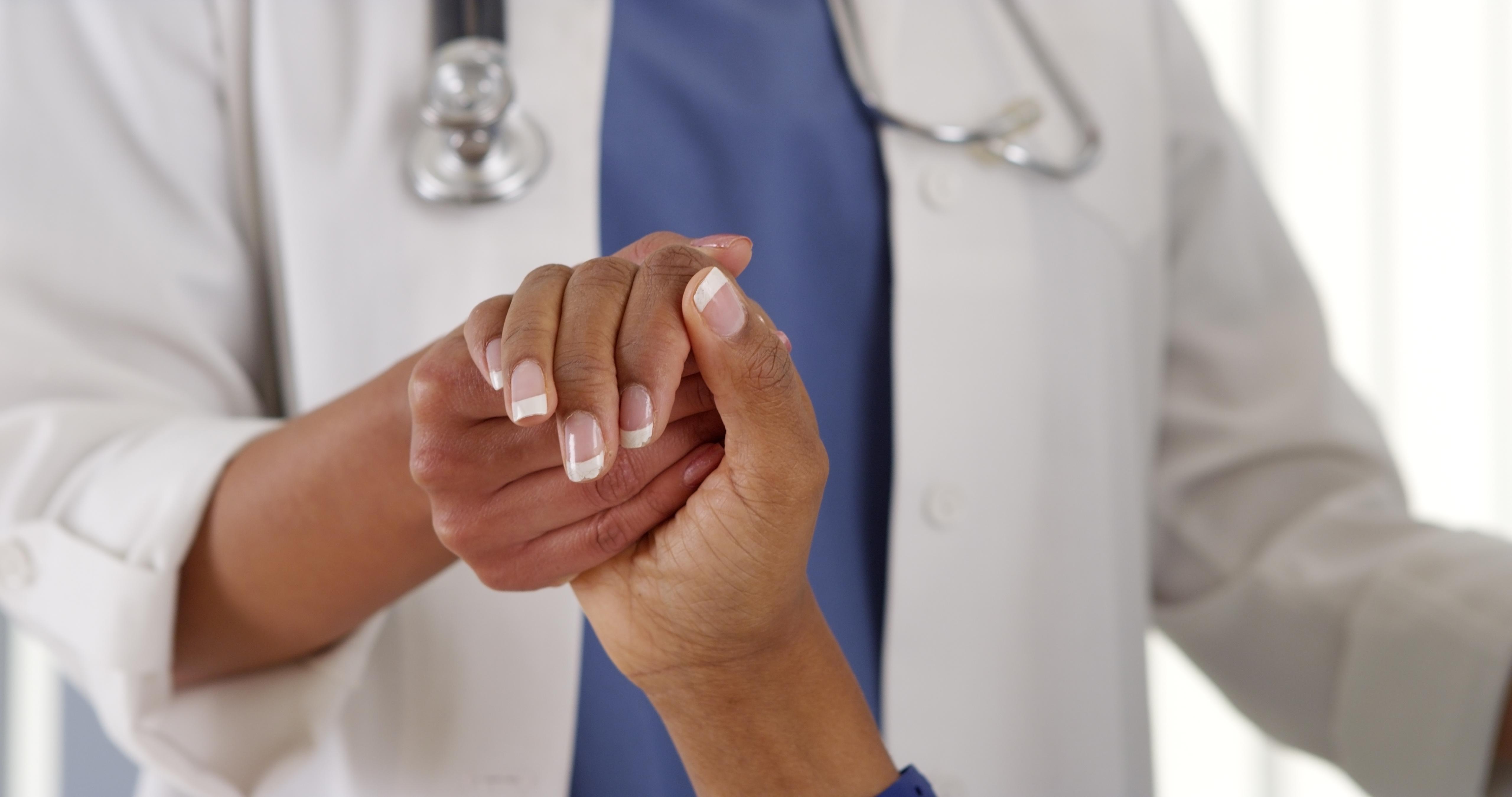 Doctor and patient holding hands.