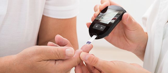 A person having their blood sugar checked by a healthcare provider.