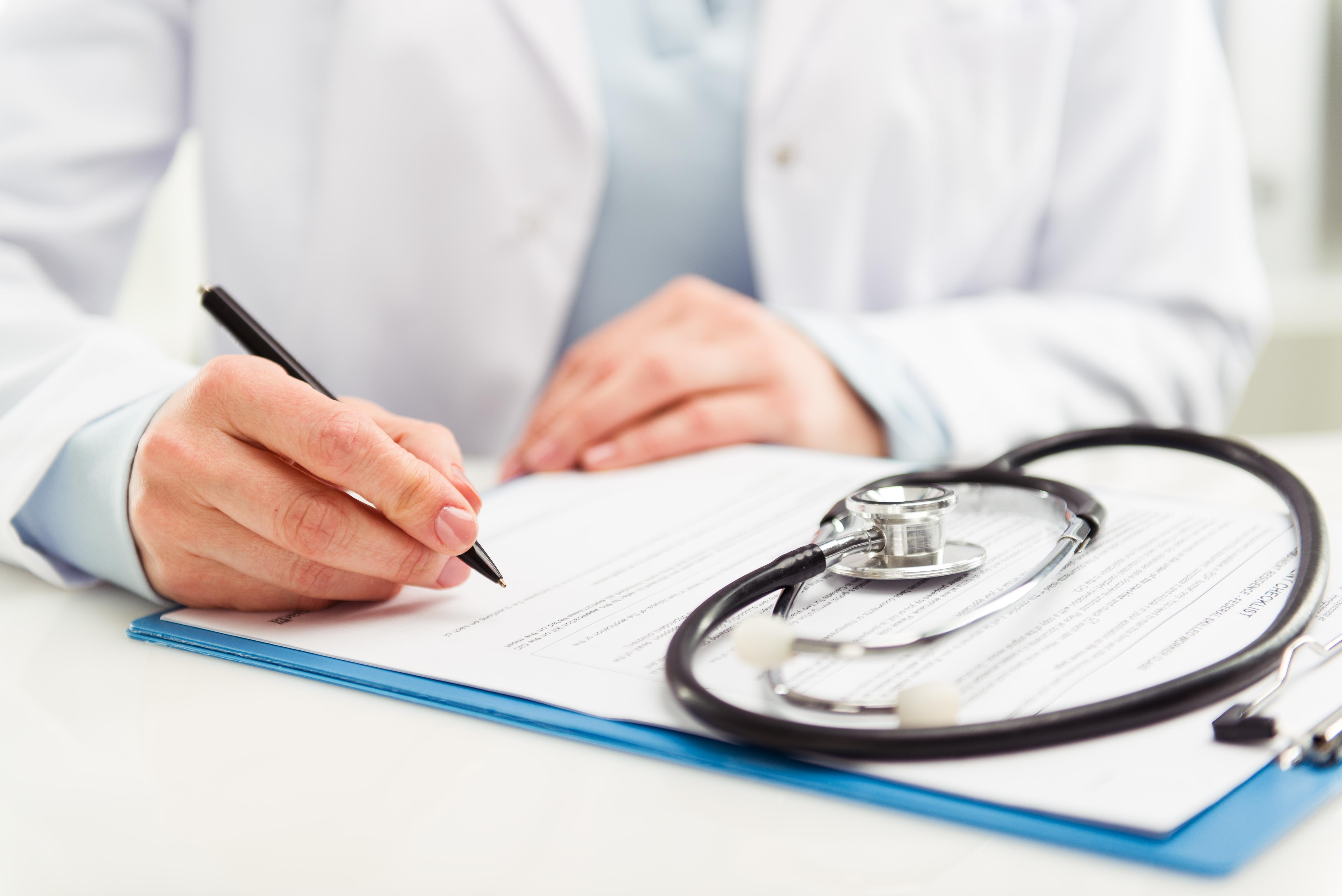 Cardiologist writing a prescription for a patient.