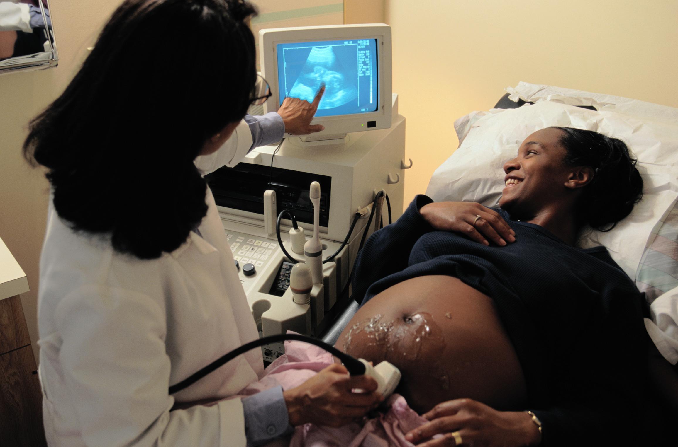 A pregnant Black woman undergoing an ultrasound