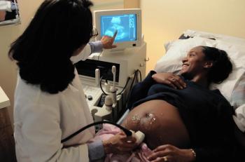 A pregnant Black woman undergoing an ultrasound