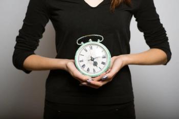 Woman holding a cloa clock.