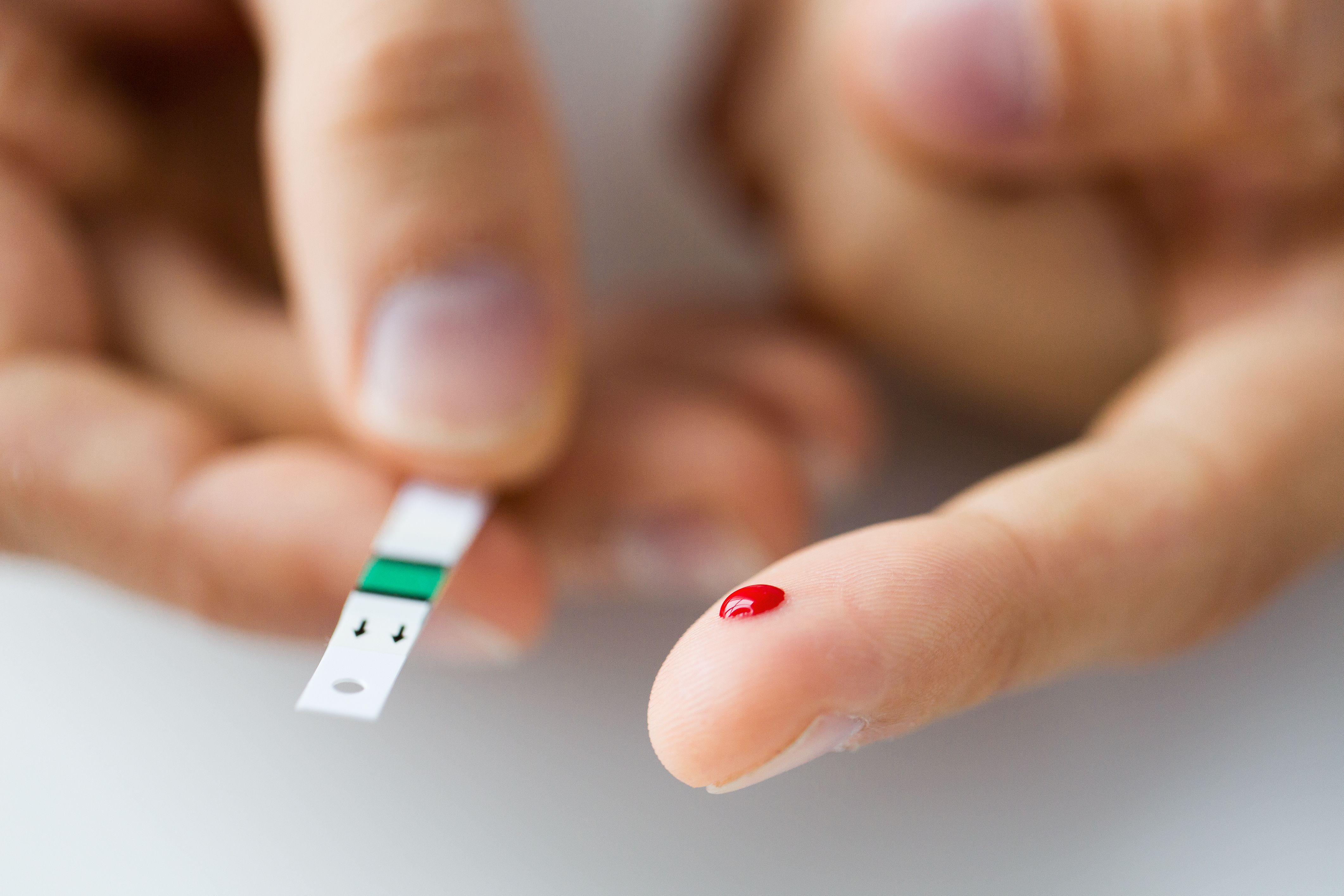 A person checking their blood sugar levels with a health care provider