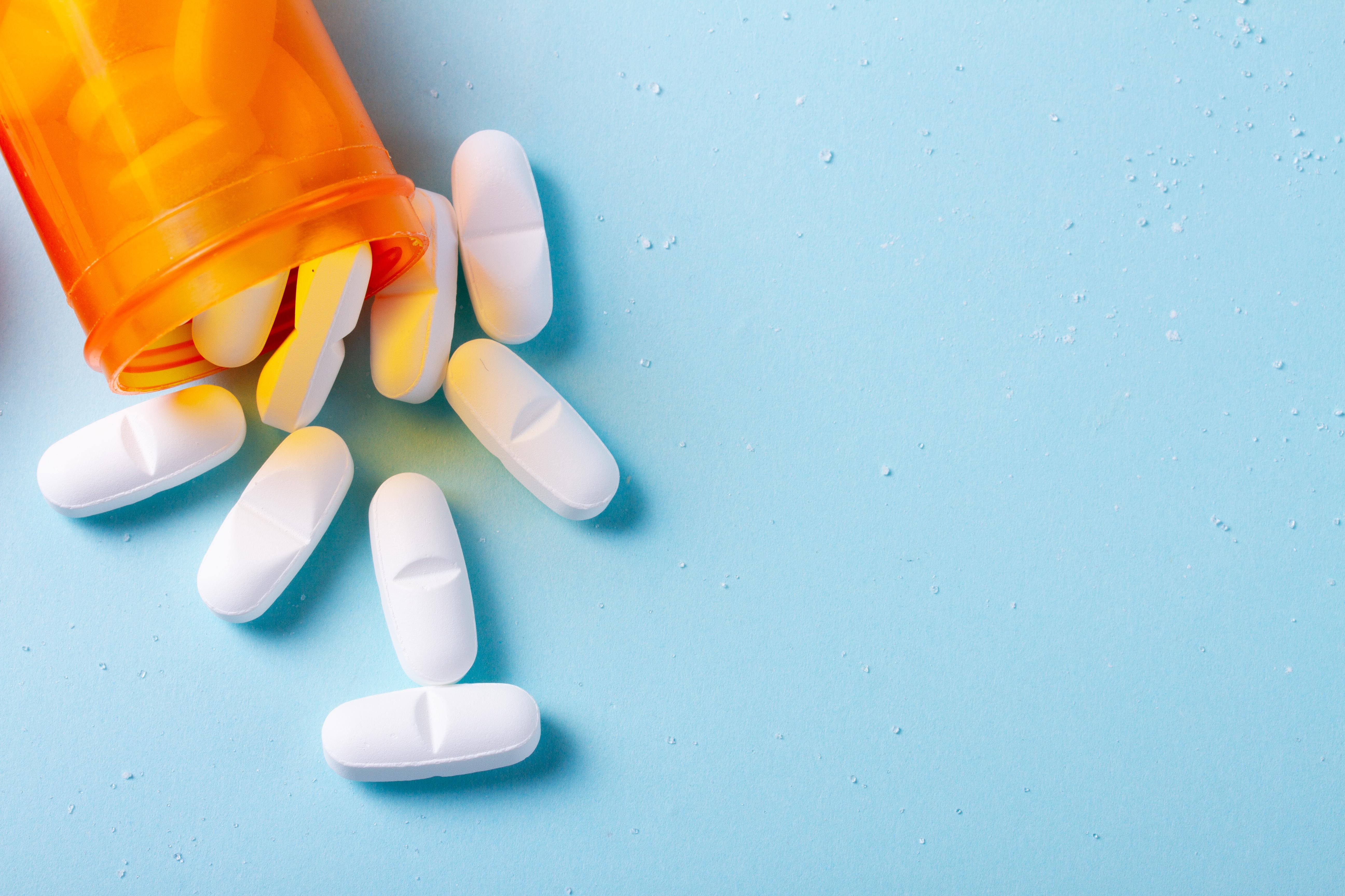 Statins spilling out of a prescription pill bottle.