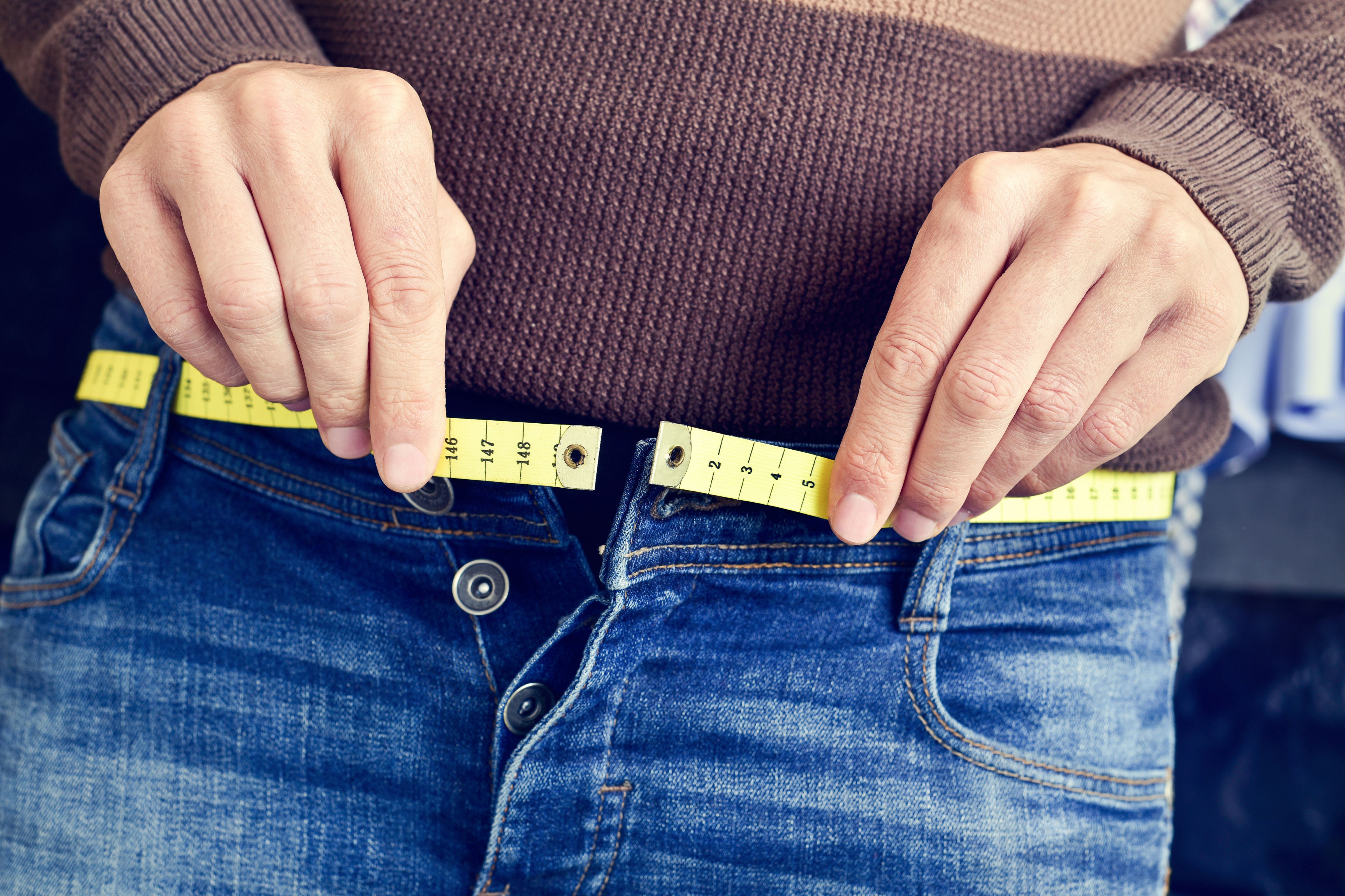 Someone measuring their waist.