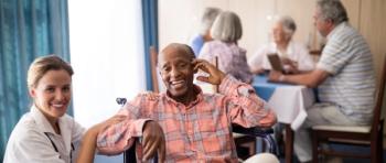Long-term care worker sitting with residents