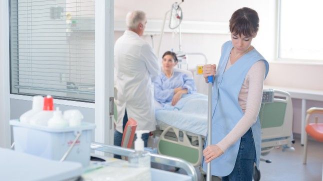 Employee mopping patient room 