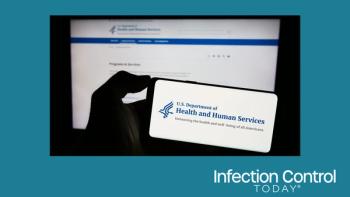 Person holding a mobile phone with the logo of the US Department of Health and Human Services (HHS) in front of a web page.  (Adobe Stock 672110075 by Timon)