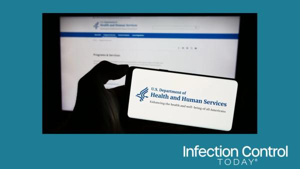 Person holding a mobile phone with the logo of the US Department of Health and Human Services (HHS) in front of a web page.  (Adobe Stock 672110075 by Timon)