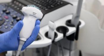 ultrasound transducer held in gloved hand