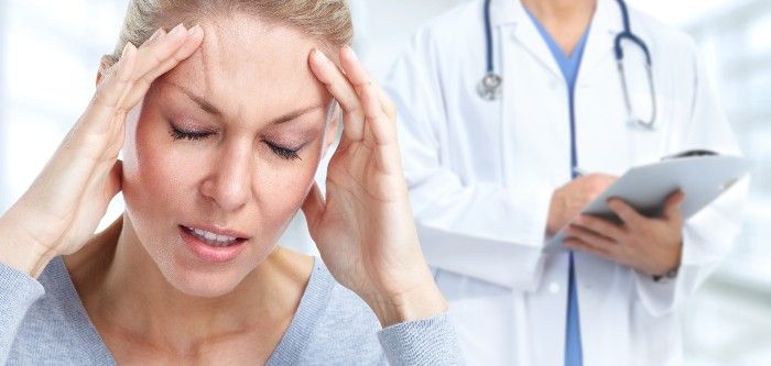 female patient holding her head