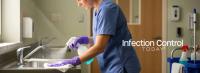 Health care worker disinfecting a stainless steel sink in a medical facility for hygiene (Adobe Stock 1692271572 by Digion)
