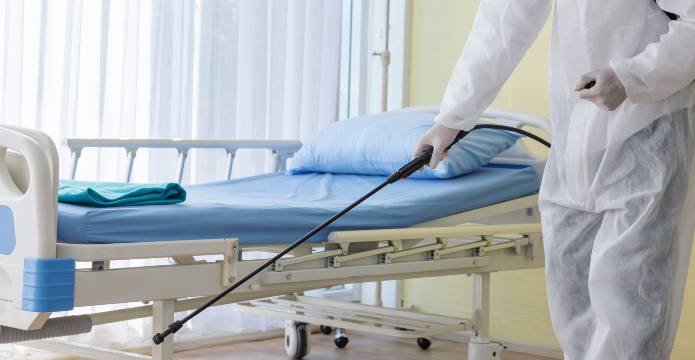 environmental person disinfecting hospital room 