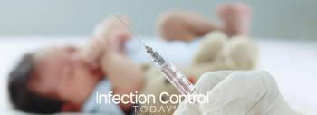 A doctor's hand wearing a medical glove holds a syringe against a blurred background of a small, crying newborn infant lying down during vaccination. (Adobe Stock 476226620 by Stella)