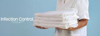 A health care professional presents a stack of pristine white textiles. (Adobe Stock 1506900633 Travel Studio Stock) 