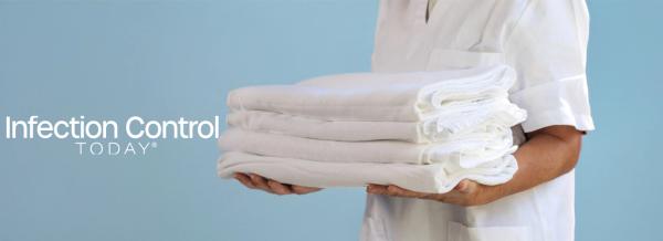 A health care professional presents a stack of pristine white textiles. (Adobe Stock 1506900633 Travel Studio Stock) 