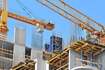 Crane and building construction site against blue sky ©Unkas Photo stock.adobe.com