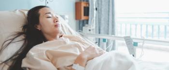 woman lying ill in hospital bed