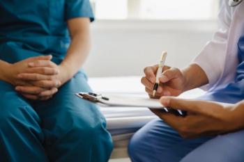 Doctor writing on clipboard with patient ©Witoon-stock.adobe.com