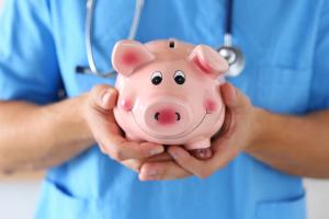 piggy bank held by doctor