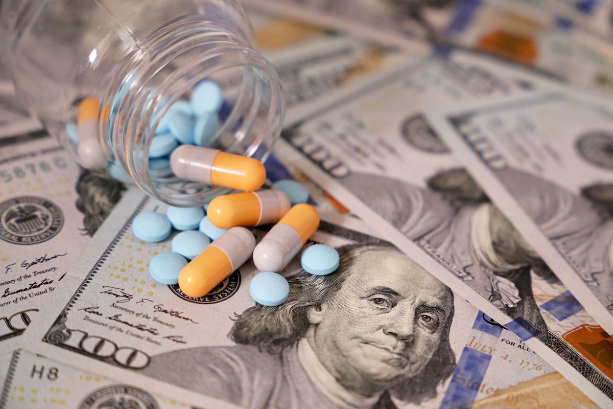 pills and capsules in bottle on us money: © Oleg - stock.adobe.com